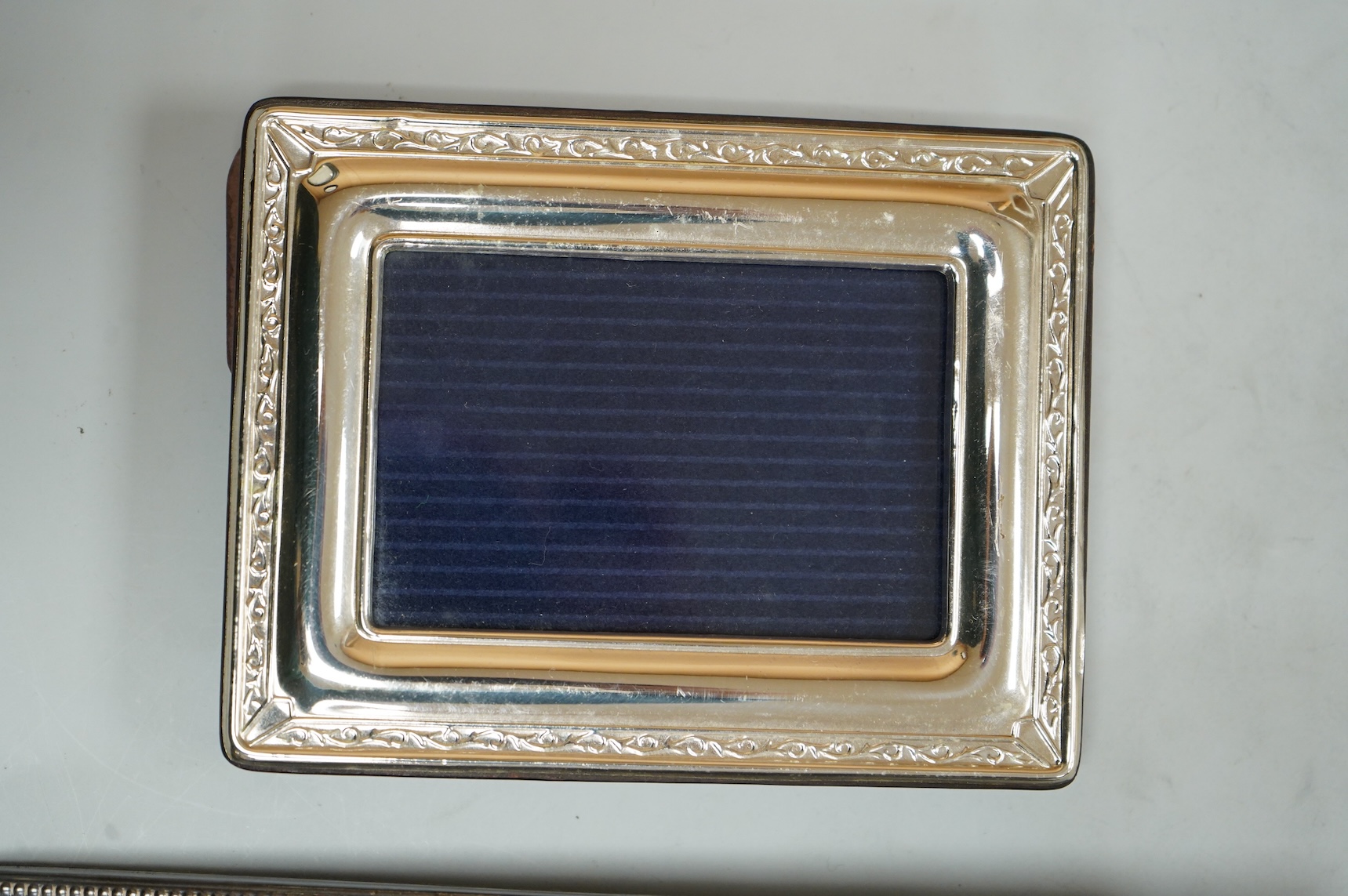Two modern silver mounted photograph frames, largest 20.4cm by 15.2cm, an Italian 925 mounted photograph frame and a modern silver mounted desk timepiece.